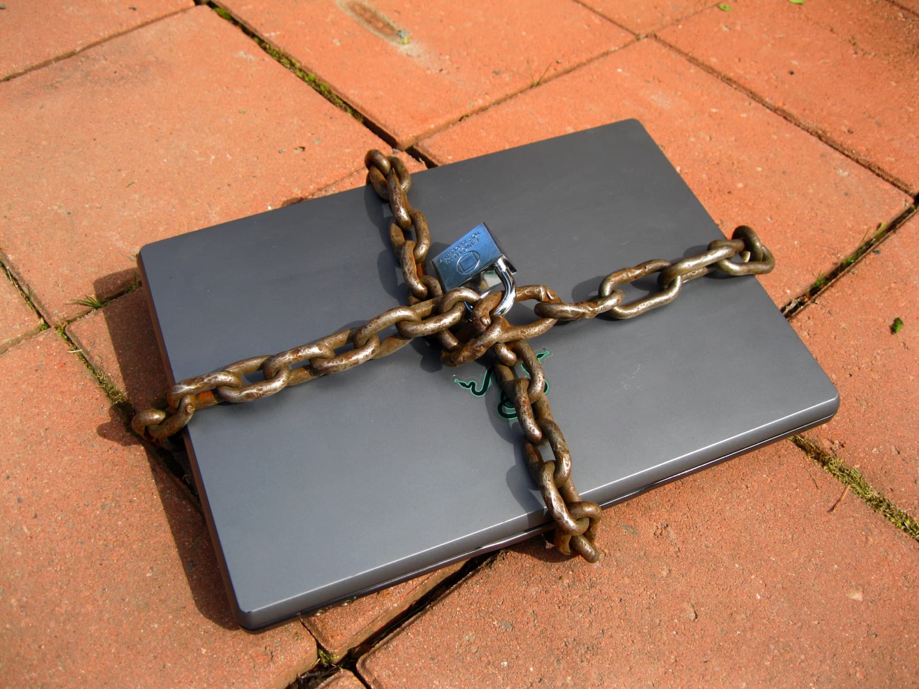 A laptop secured with a chain and padlock